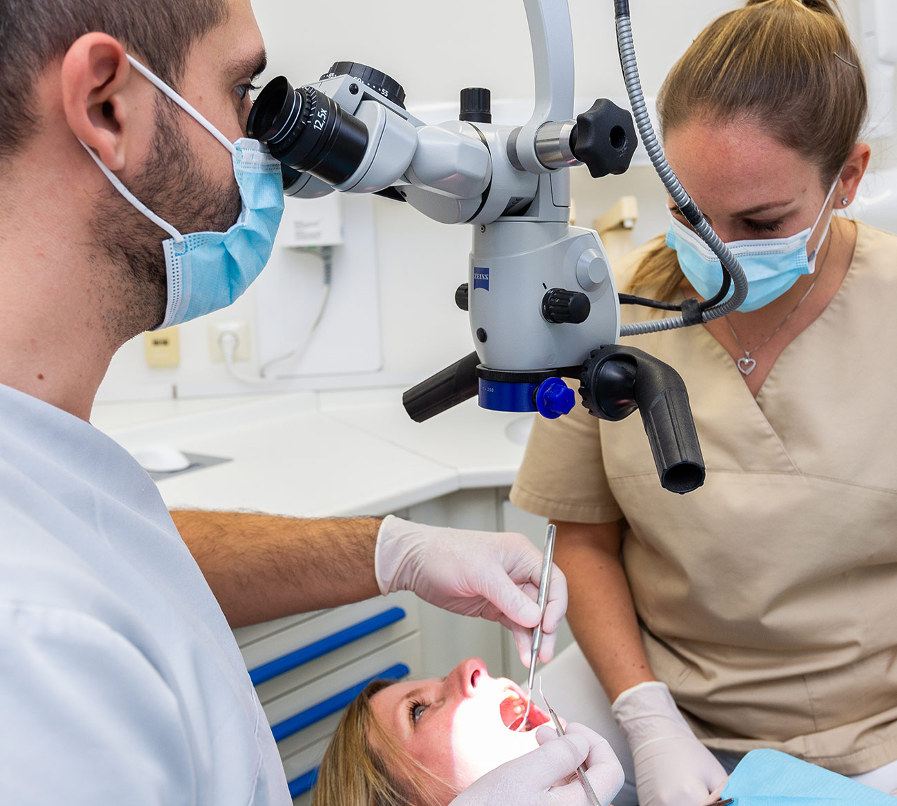 Foto von einer Mitarbeiterin, die die Position des Röntgengerätes für die Patientin auf dem Behandlungsstuhl einstellt
